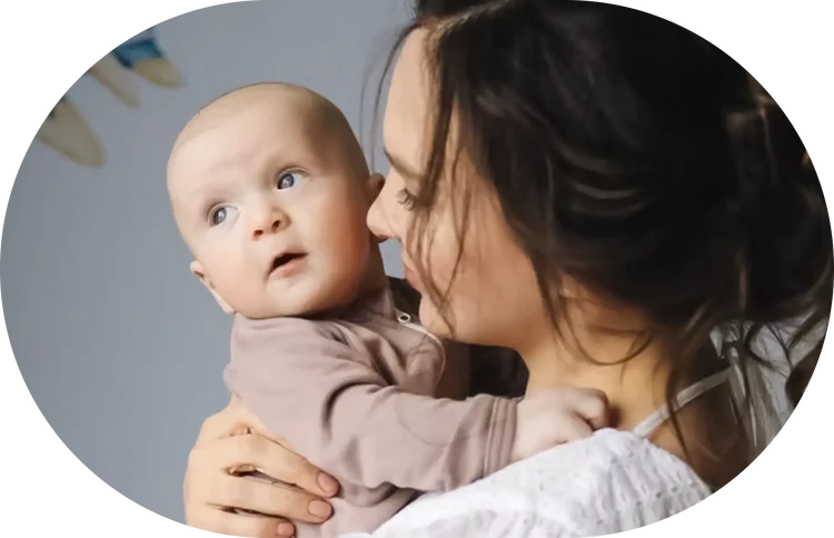 A parent holding their newborn close, in soft natural light